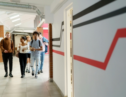 Students walking down the high school hallway together.