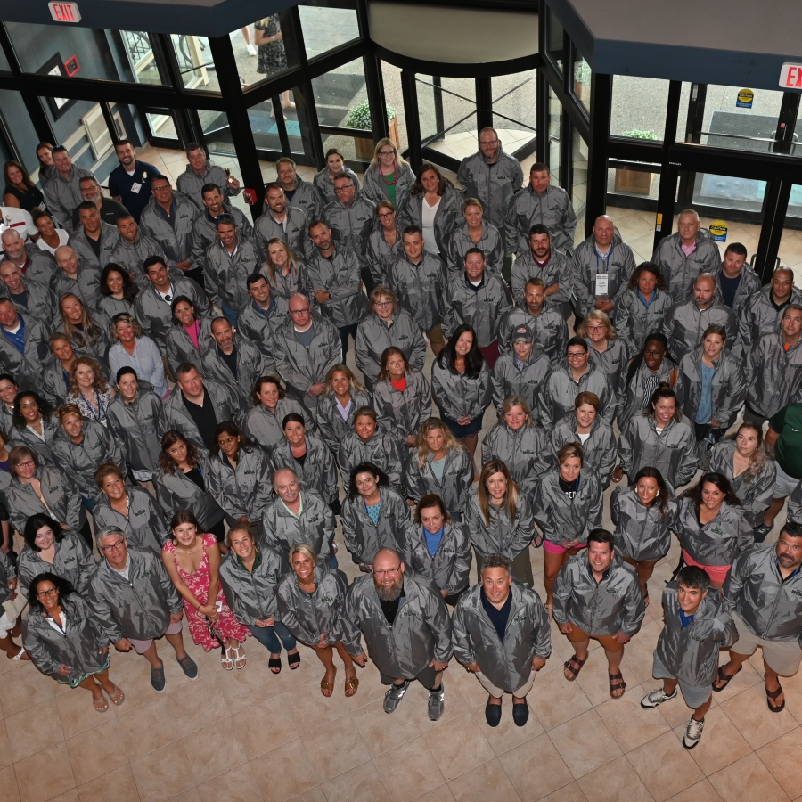 a large group of people stand together looking up at the photographer