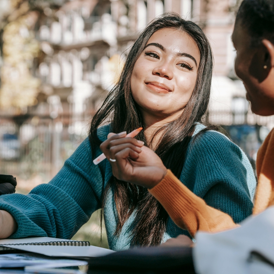 Two high school students enjoying a conversation outside.